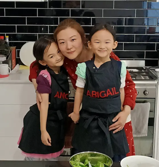 Dr Angel Lu with her two daughters wearing aprons, demonstrating family and health values