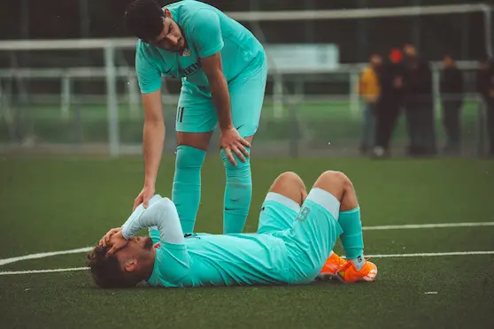 Injured football player receiving chiropractic care for sports injury recovery in Brisbane
