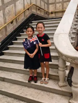 Dr Angel Lu’s two daughters holding the Australian flag at Brisbane City Hall