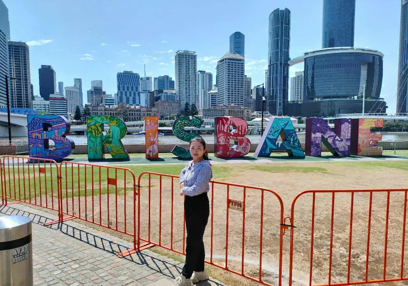 Dr Angel from Angel Chiropractic standing in front of the Brisbane sign, representing her dedication to providing quality chiropractic care across Brisbane.