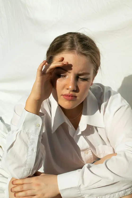 Lady shielding face from Brisbane sun with headaches – Angel Chiropractic headache relief