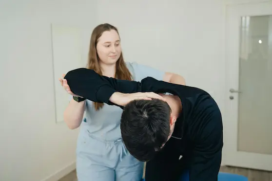 Female chiropractor providing gentle chiropractic treatment to a patient in a modern clinic
