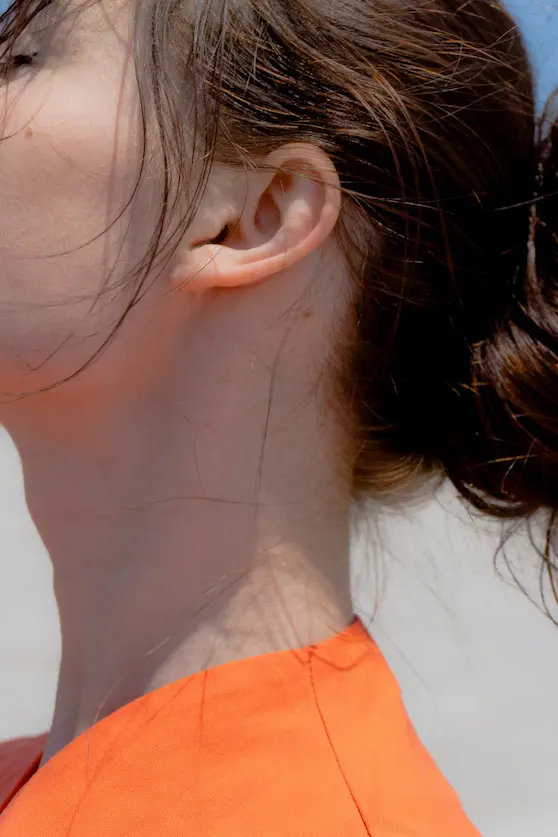 Female experiencing pain in right side of neck under ear, highlighting neck tension and muscle strain – Angel Chiropractic Brisbane